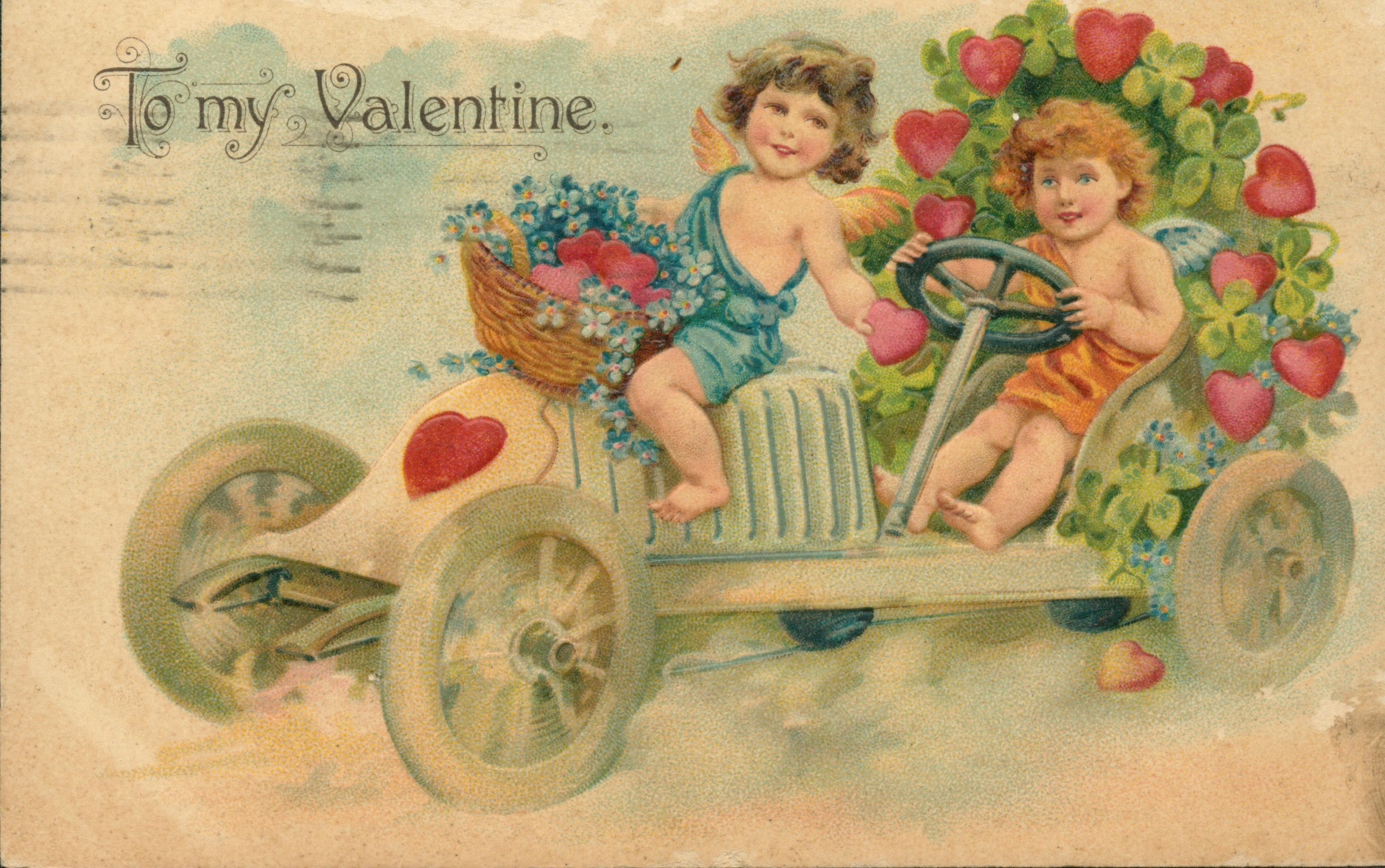 Shows two children festooned with flowers and clover driving a car