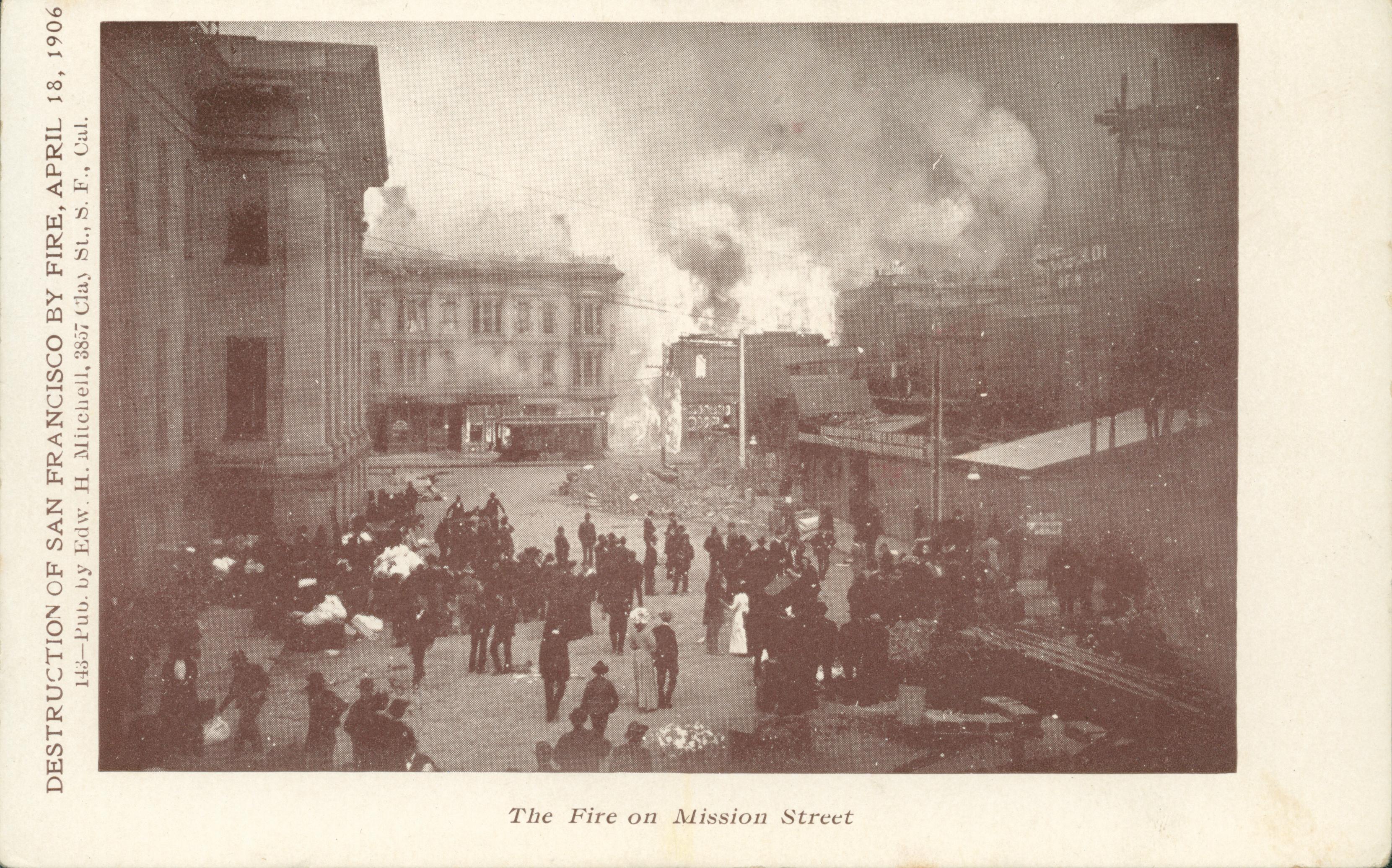 Shows a crowd of people watching several buildings burn.