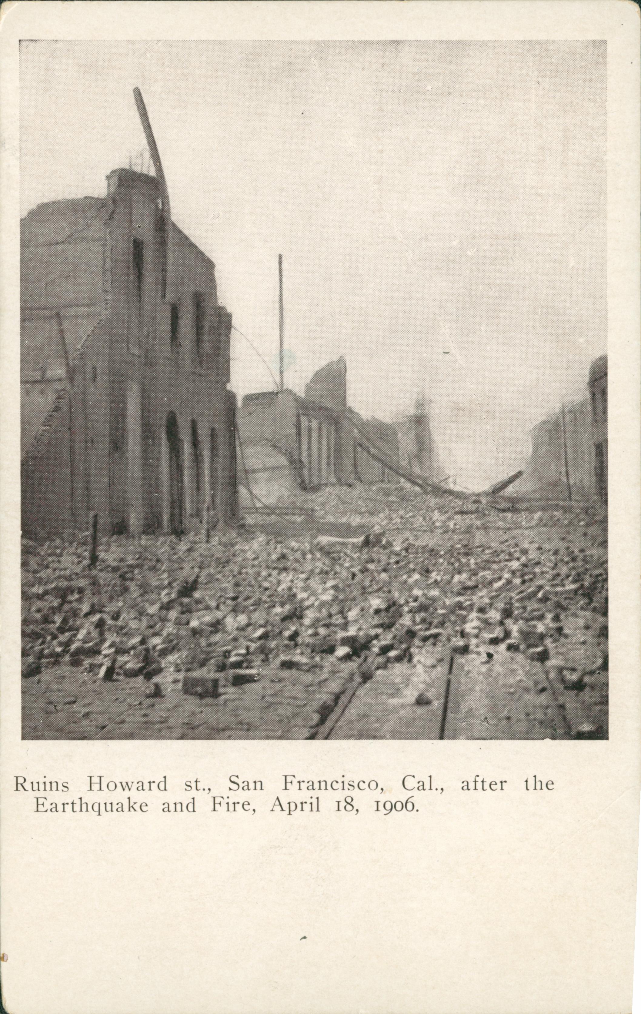 Shows Howard St. covered in rubble with destroyed buildings on both sides of the street.