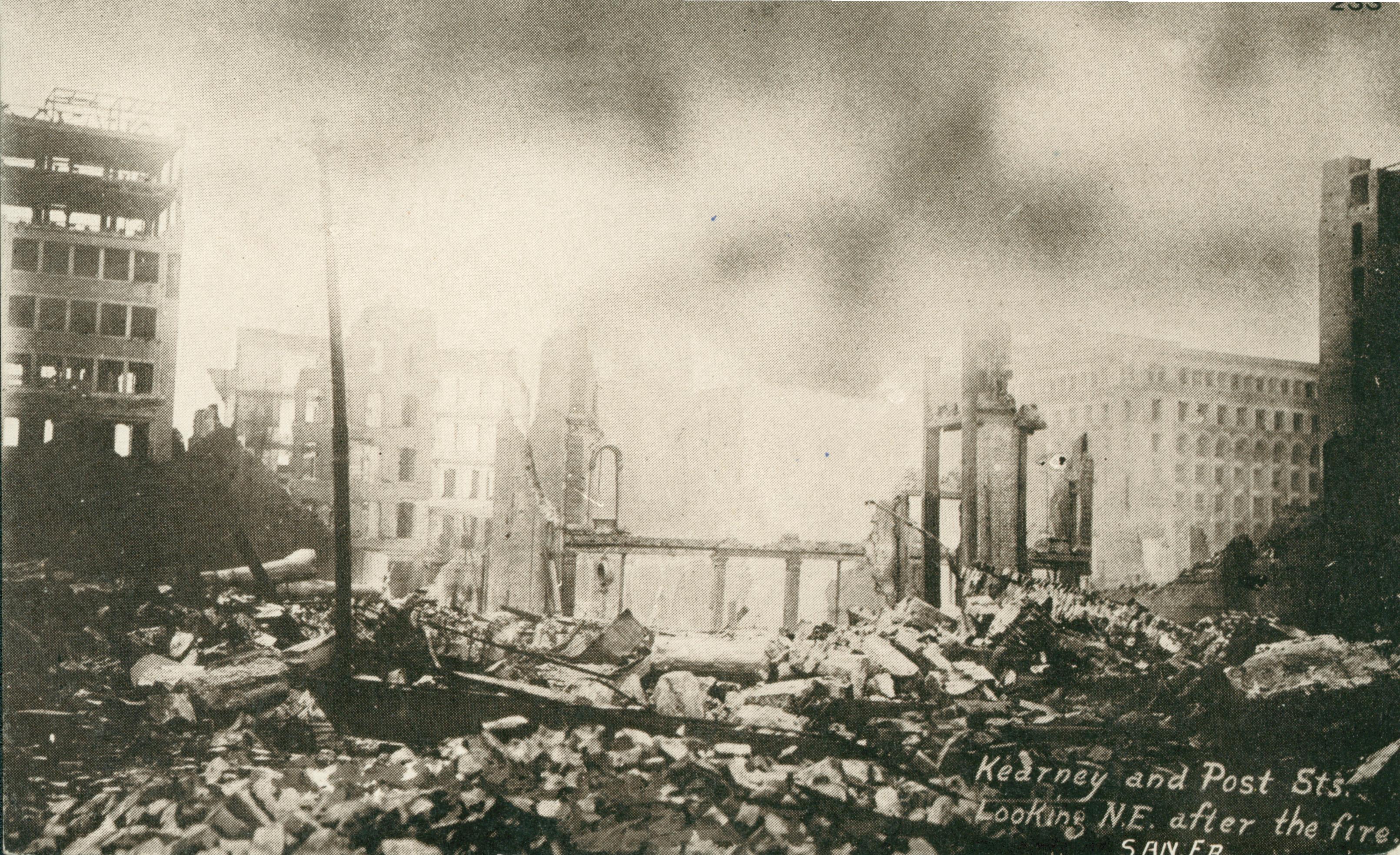Shows a large pile of rubble with building standing in the background.