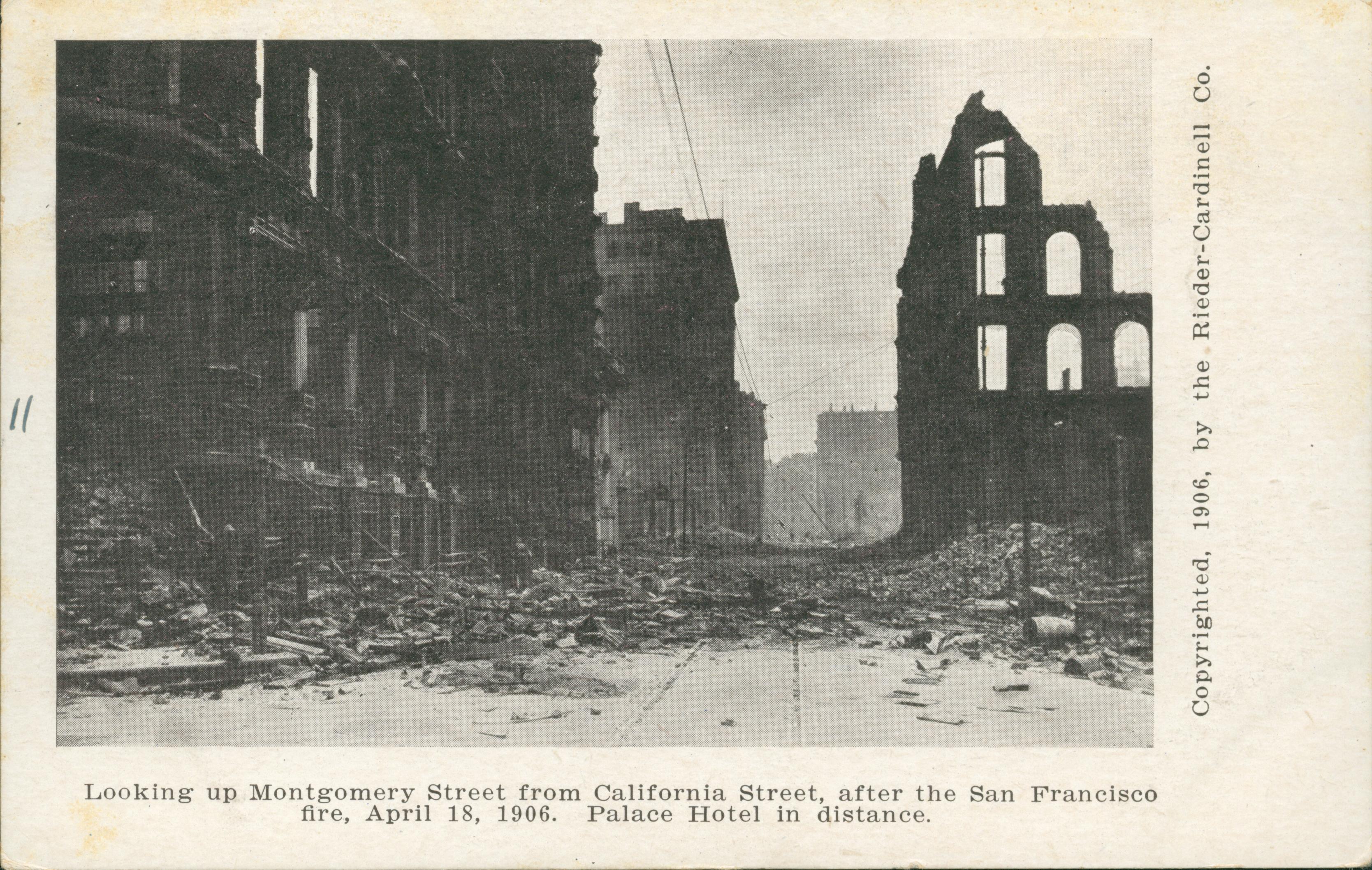 Shows destroyed building on both sides of a street with the Palace Hotel in the background.