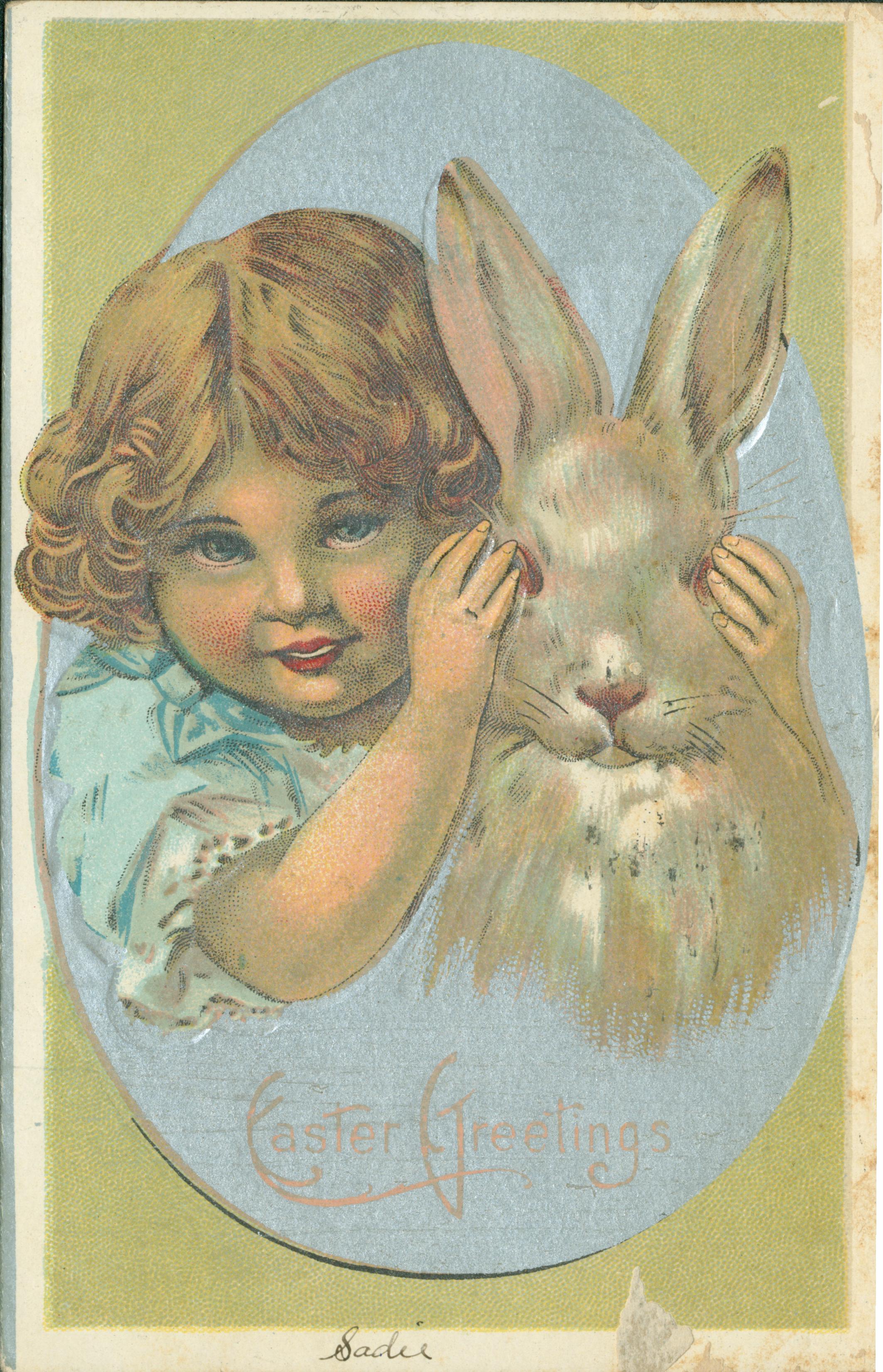 A young girl covering the eyes of a rabbit.