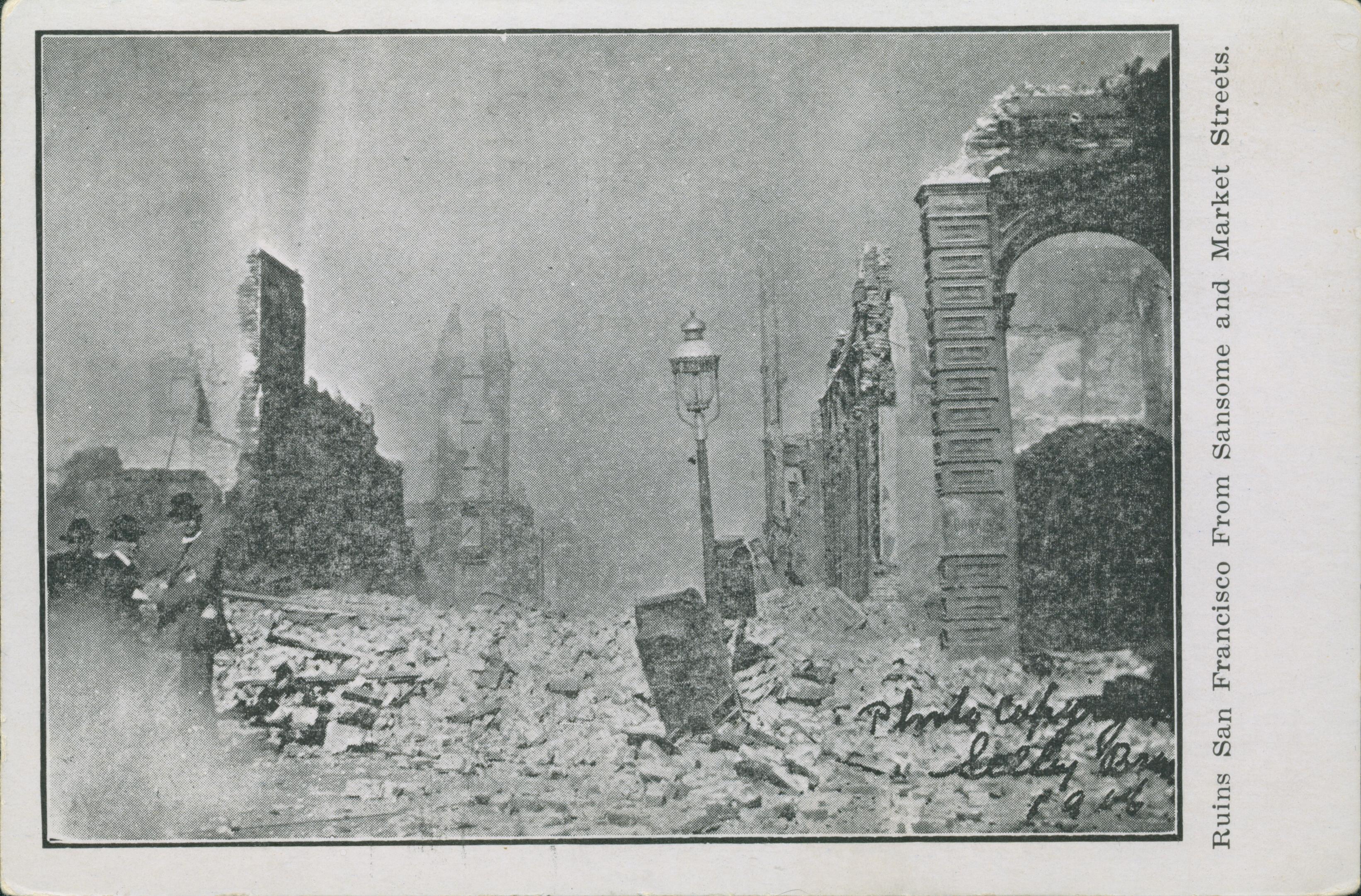 Shows three men standing among piles of rubble and surrounded by ruined buildings.