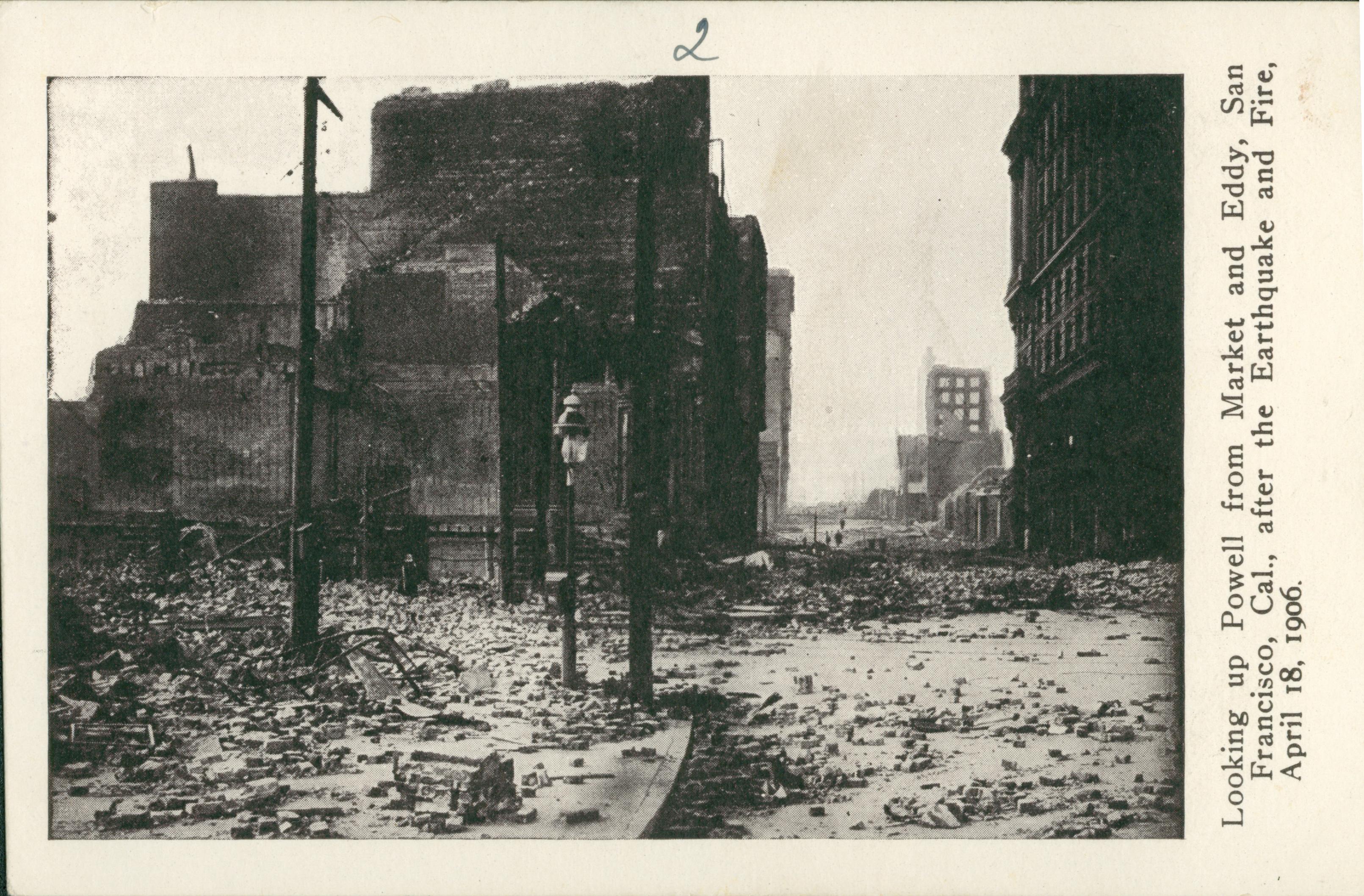 Shows the street covered in rubble with a collapsed building on the left.