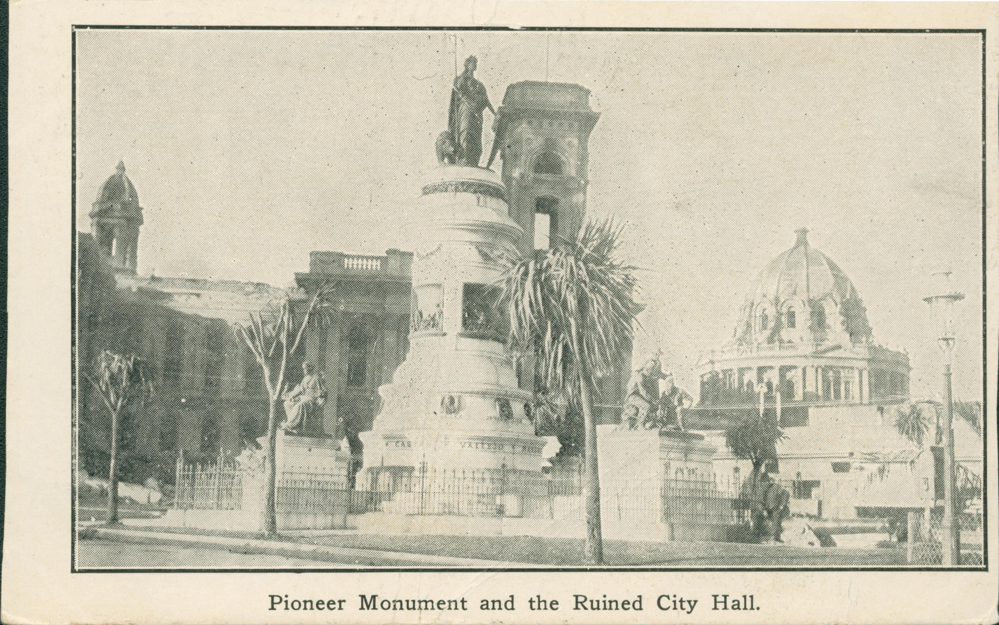 Photo of the Pioneer Monument with a ruined City Hall in the background.