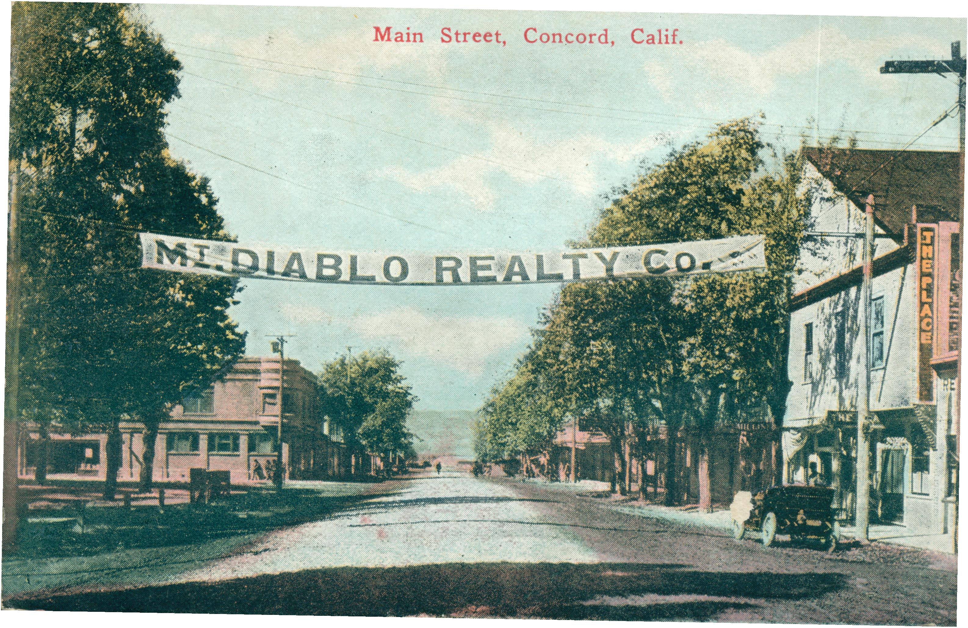 View of a street and several buildings with a banner for Mt. Diablo Realty suspended above the road