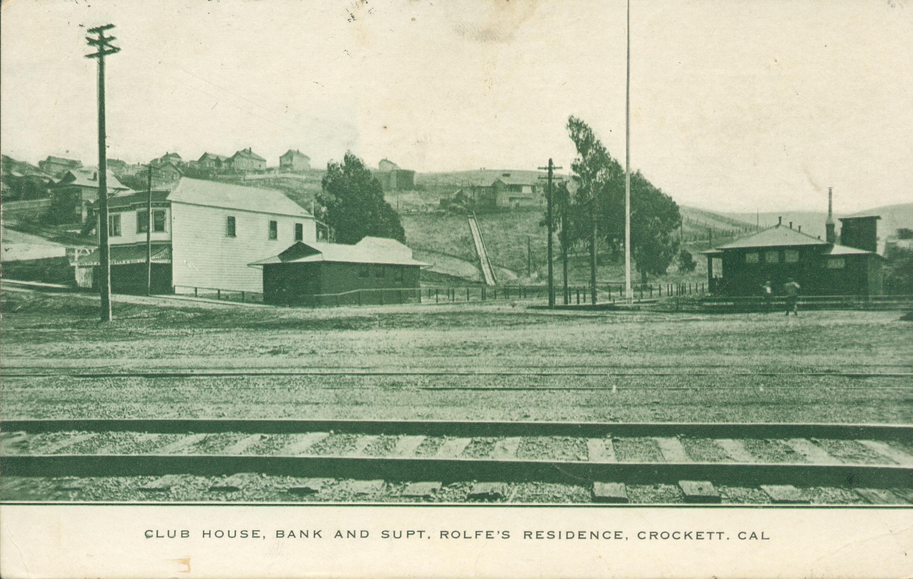 Several buildings with railroad tracks in the foreground
