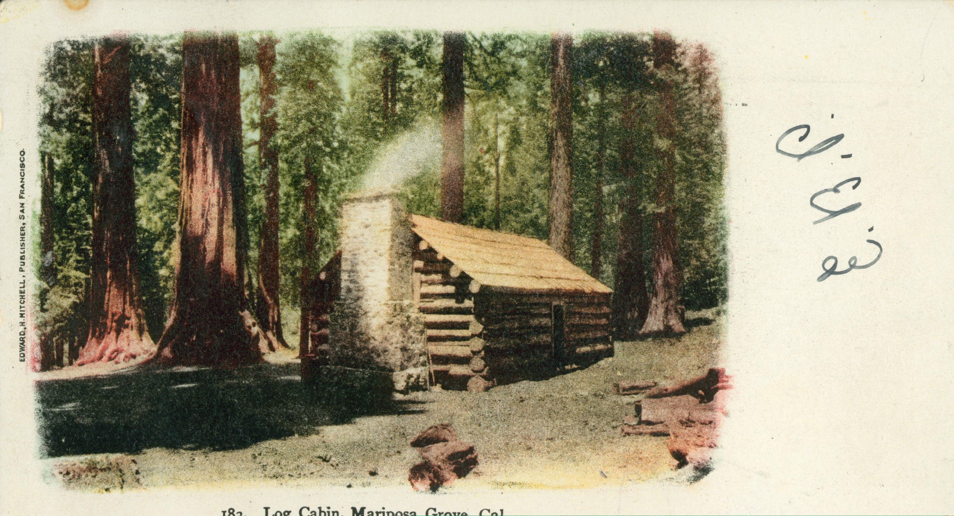 Shows a log cabin in a forest