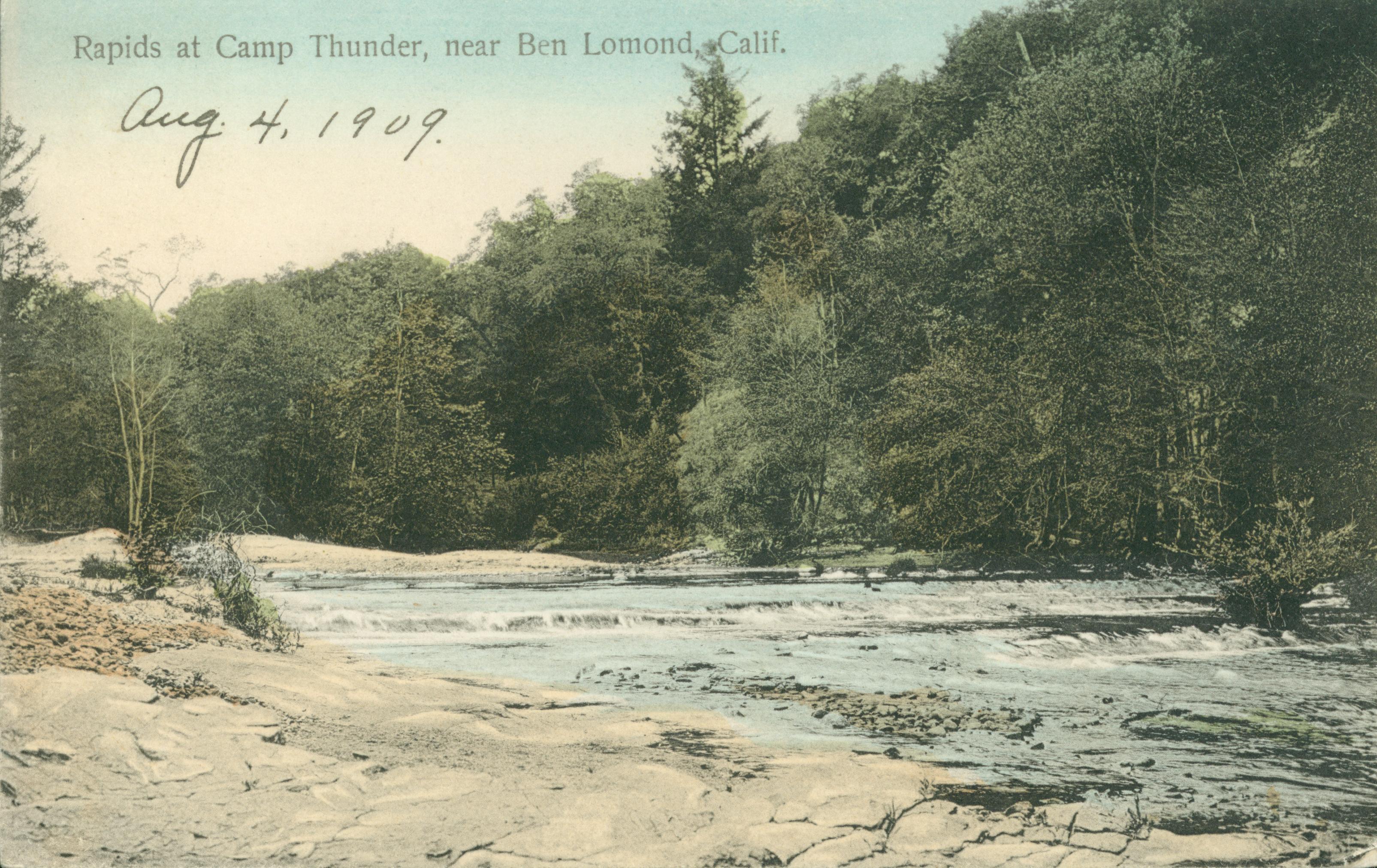 Shows a tree-lined set of river rapids