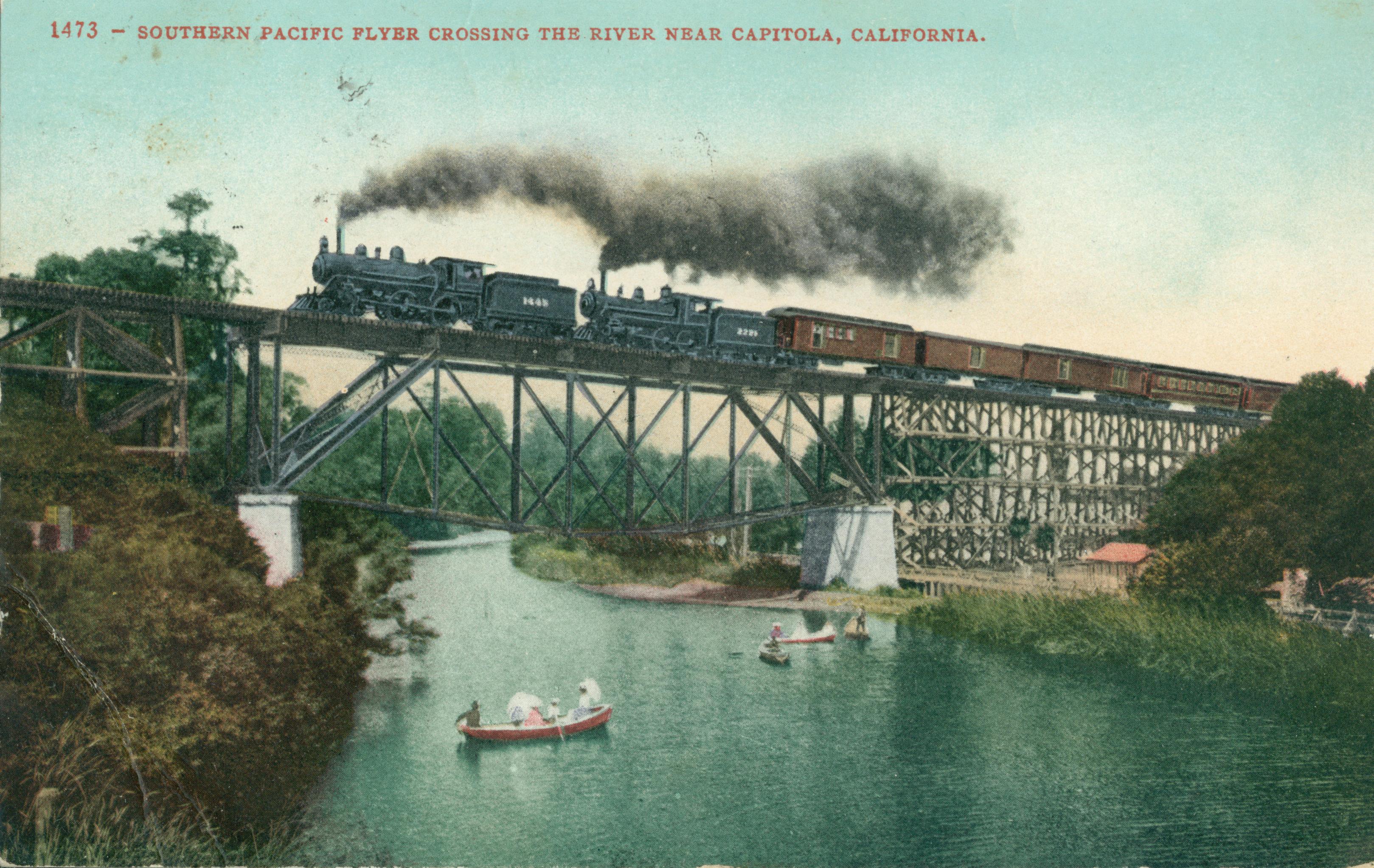 2 steam engines pulling passenger train, traveling along bridge crossing river, two small canoe-like boats in river with ladies holding parasols